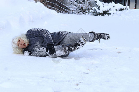 一名妇女滑倒在冬天的路上摔倒受伤图片