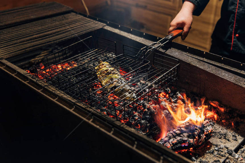 厨师在餐厅用火焰烤鱼的镜头图片