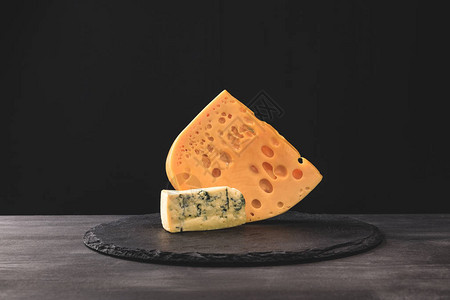 黑色板上emmental和蓝纹奶酪的特写镜头图片