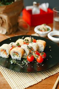 Maki寿司卷三文鱼和奶油酪黑盘上图片