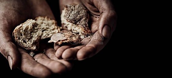 贫困概念拿着面包干的乞丐手特写图片