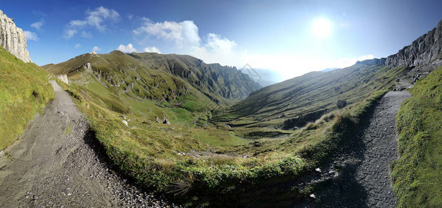 沿着高山小径的岩石和云彩的山景图片