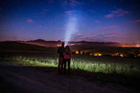 宇宙,年轻快乐的情侣拥抱在山上星光之夜背景