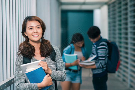 一名女孩与背景同学坐在学校走廊的同学一图片