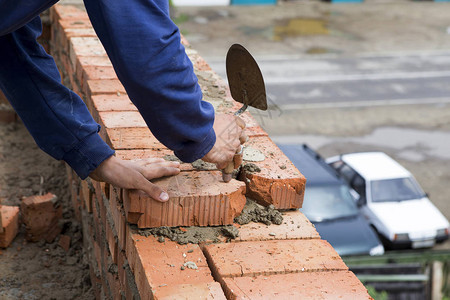 Bricklayer在砖墙建筑工地作图片