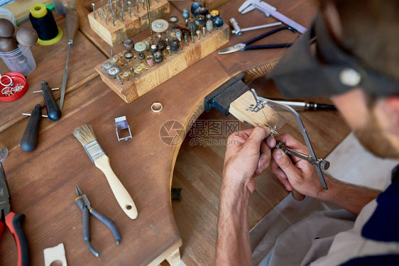 珠宝商在车间制作花环在工作站上用不同工具成型和抛光图片