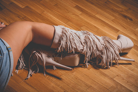 在镶木地板上穿高跟鞋长靴的女人腿图片