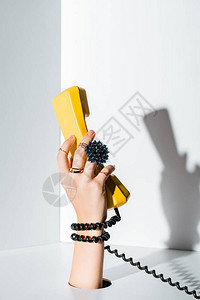 白色洞口手握着旧式电话黄色助听器的妇背景图片