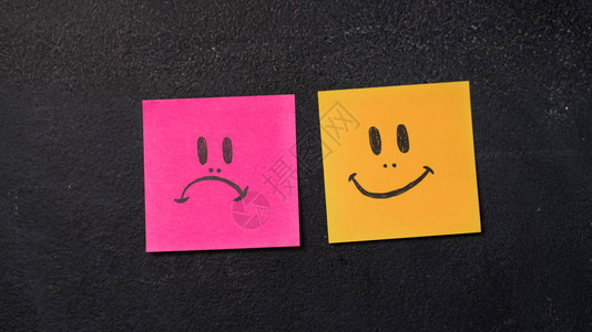 在黑板上贴着快乐和悲伤的脸图片