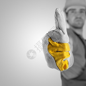 戴着防护安全帽和手套的建筑工人或建筑工人竖起大拇指表示赞同和成功图片