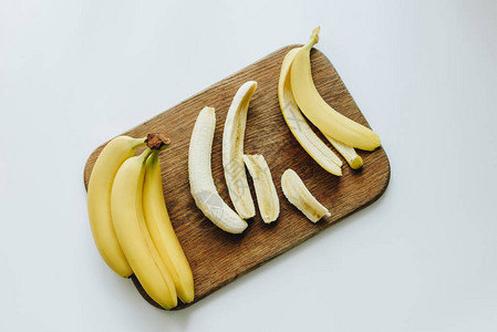 木制切割板上鲜黄色香蕉的顶部图片