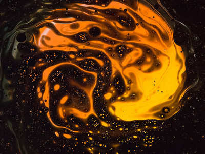 橙色背景上的烧油与水混合图片