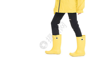 女在黄色雨衣和白色孤立的雨靴图片