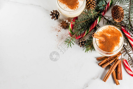 传统的冬季和圣诞节饮用带有磨碎的肉豆蔻八角星和肉桂的蛋酒图片