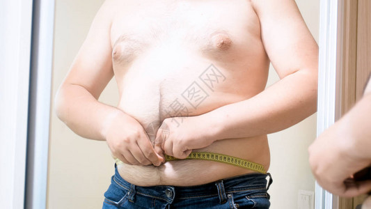 胖子用卷尺测量他的大肚子图片
