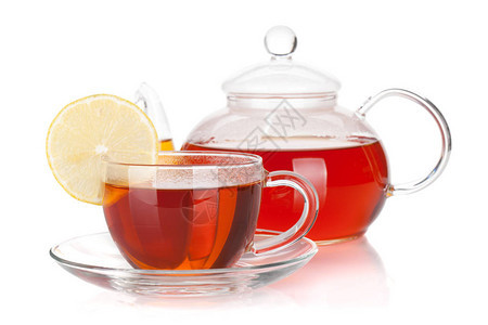 玻璃茶壶和一杯红茶与柠檬片隔离在白色背景图片