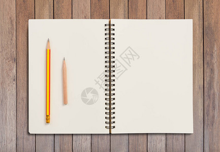 平面空白笔记本和铅笔放在木板背图片