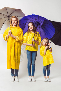 穿着黄色雨衣的幸福母亲和女儿图片