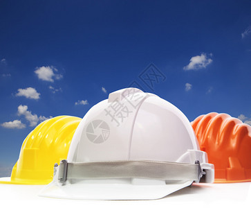 白色安全头盔建筑保护三件以白色遮挡美丽的蓝天空和白云并图片