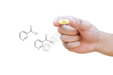 手拿着维生素B3丸与剪报图片