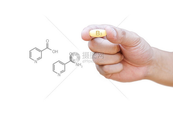 手拿着维生素B3丸与剪报图片