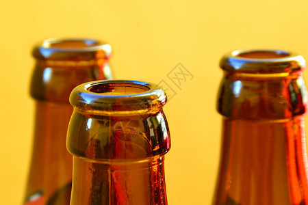 黄色背景的空啤酒瓶图片