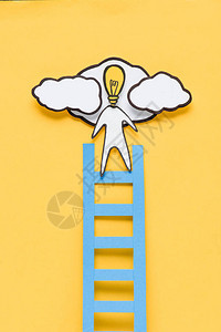 纸板男子的顶部视图灯泡头在黄色背景上爬梯图片