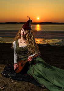 穿着中世纪礼服和帽子的女孩在湖图片