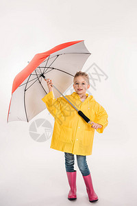 穿着橡胶靴子带雨伞的黄色雨衣在图片
