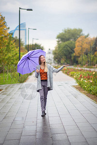 一个女孩在雨伞下走在阴云的天气下图片