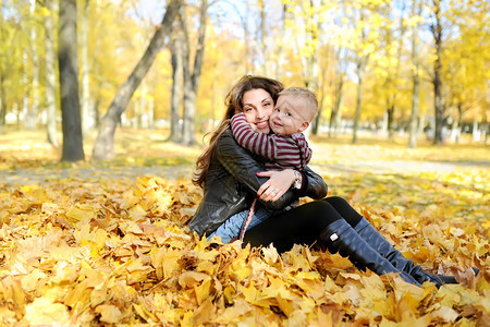 母亲和孩子在秋天公园走图片
