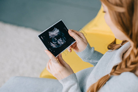 在观看超声波扫描的有吸引力的孕妇形象被图片