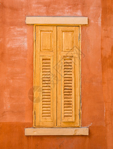 橙色墙壁背景上的木窗图片