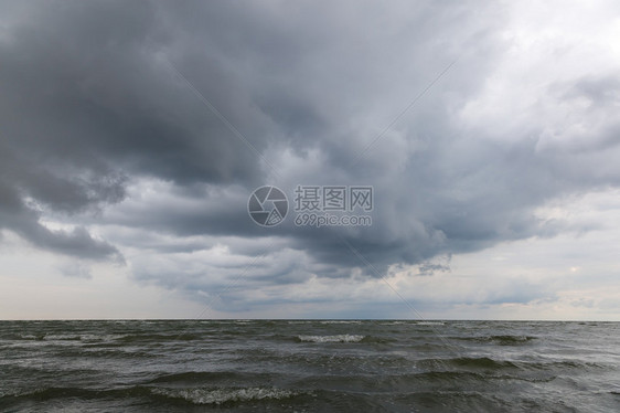 在风雨如磐的天空的沙滩上的海浪图片