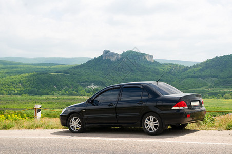 路上的黑色汽车与山景相映成趣图片