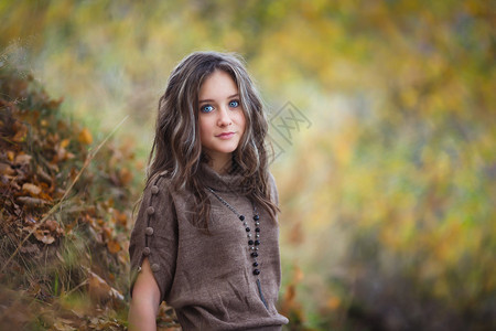 黄色树叶背景的美丽年轻女孩的肖像图片