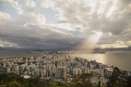 城市区的全景建筑物和海湾上闪耀着光线远处雨云多彩云弗洛里亚诺波利斯圣卡图片