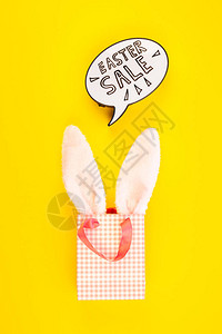 创意顶视图平躺假日促销组合复活节销售耳朵鸡蛋短信在粗体黄纸背景复制空间模板复活节日季图片