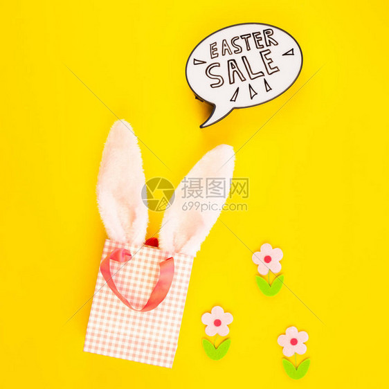 创意顶视图平躺假日促销组合复活节销售兔子耳朵鸡蛋短信在粗体黄纸背景复制空间模板复活节日季图片