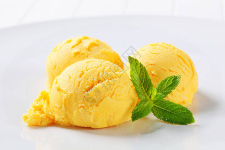 盘子上三勺黄色冰淇淋图片