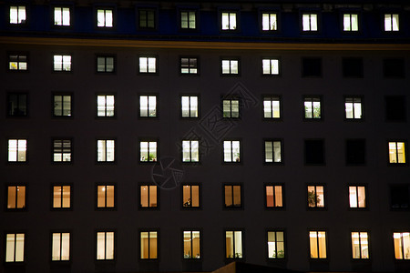 夜间灯光照亮的商房窗户图片