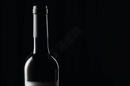 瓶装酒和黑色的黑包装纸背景图片