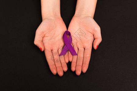 黑色背景上捧着紫色丝带的女生双手图片