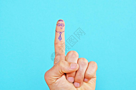 拇指触摸中指的亮片蜡手高清图片在食指和一只手的中指上画了两张脸