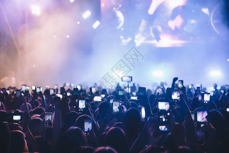 人们在音乐娱公共音乐会期间用触摸智能手机拍照现场演唱会音乐节快乐青春奢华派对景观外景图片