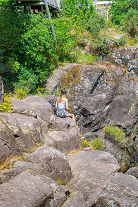坐在岩石上的女生背影照片图片