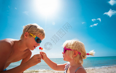 孩子们在沙滩上吃着棒棒糖图片
