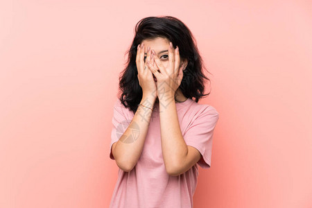 年青妇女超过孤立的粉红背景遮住眼图片素材