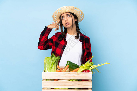 年轻农妇在木篮子里拿着新鲜蔬菜做疯狂的手势图片