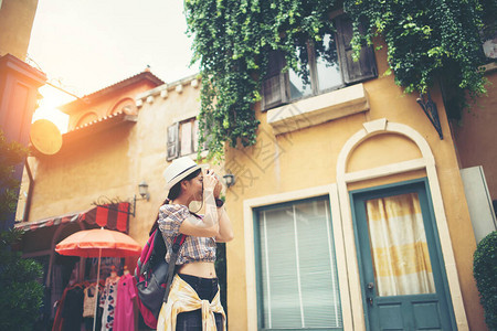 年轻时髦女人背包旅行在城市拍照的肖像快图片